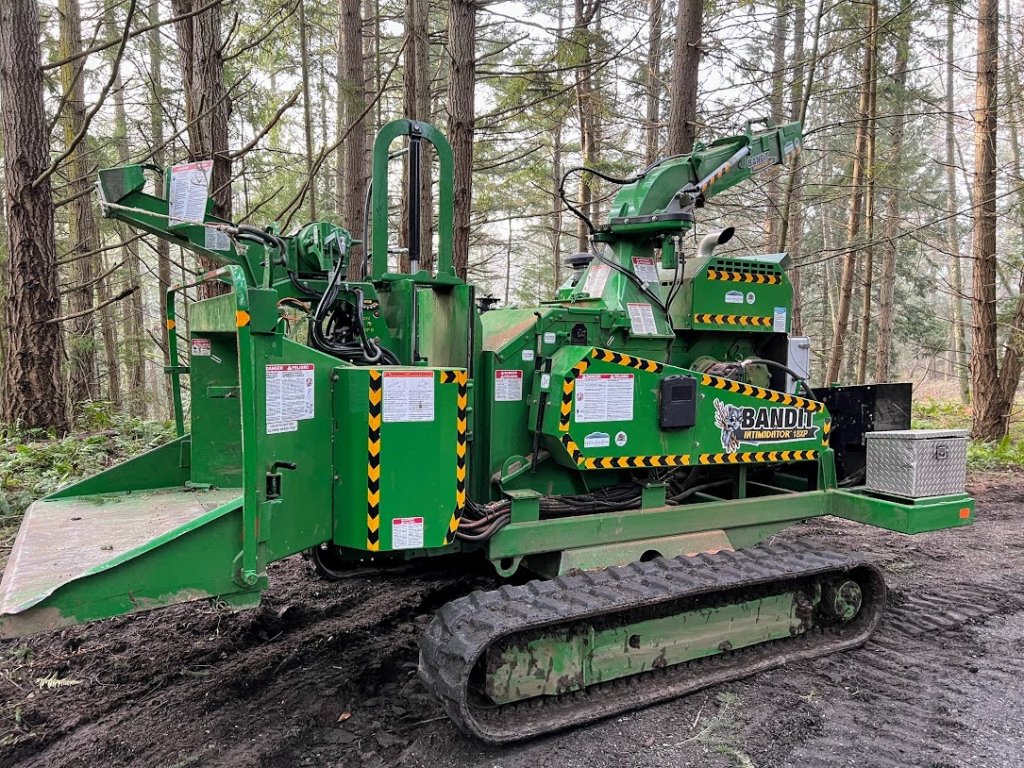 An image of a Bandit Intimidator 18XP tracked chipper parked in the woods